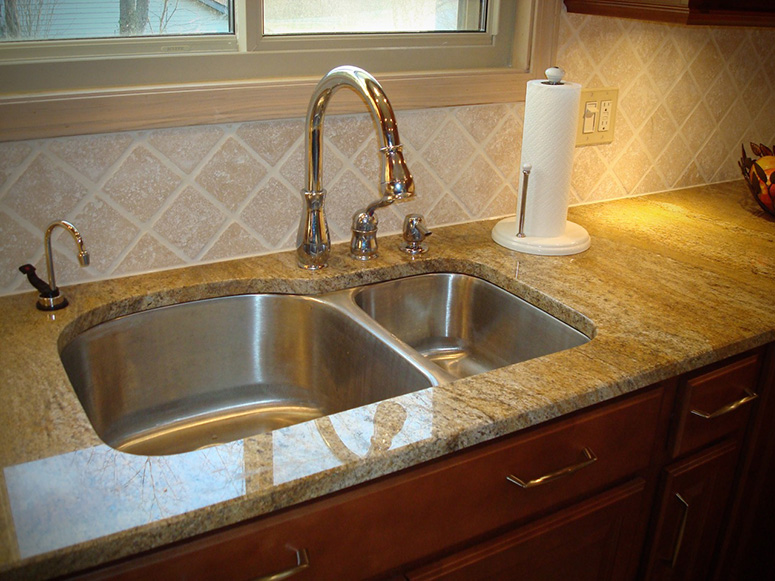 Photo: Detail photograph of a granite countertop with undermounted sink.