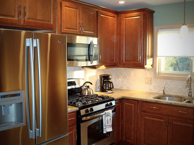 Photo: A full kitchen including stainless steel appliances, granite countertop, and undermount sink.